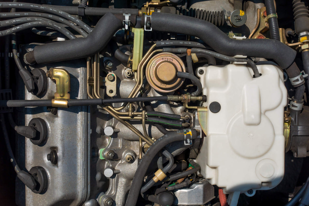 Detailed view of Honda Acty Van engine components for HH3, HH4 models from 1990-1999, showcasing OEM-quality exhaust manifold, water pump, and valve system available at Oiwa Garage.