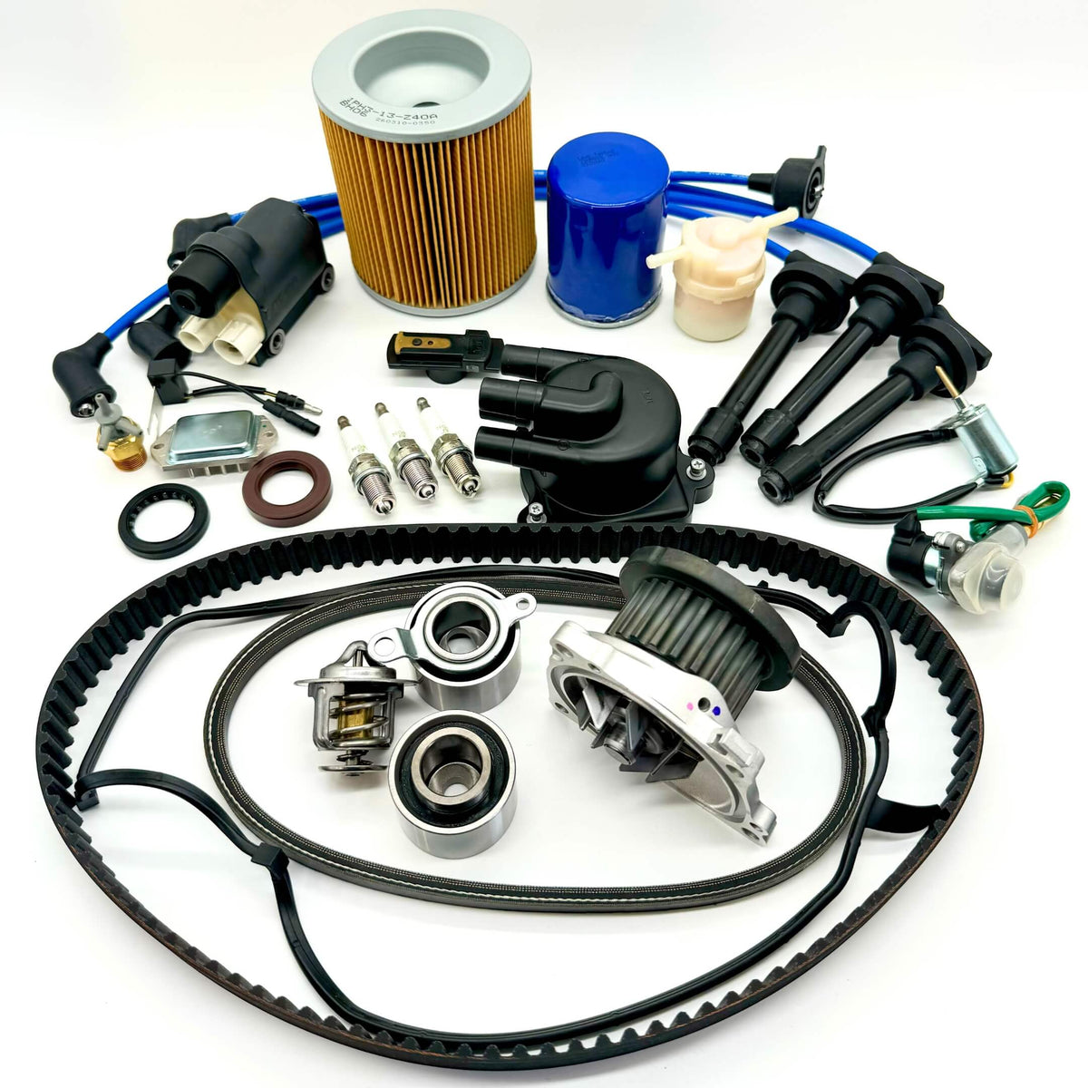 22-piece Mega Timing Belt and Tune-Up Kit for 1990-1999 Honda Acty HH3/HH4, including premium air filter, fuel filter, oil filter, distributor cap and rotor, high-performance spark plugs with wires, ignition control module, coil sensor, ignition assembly, complete engine gasket set, timing and alternator belts, and air thermal valve, all arranged on a white background, ready to ship free from Oiwa Garage.