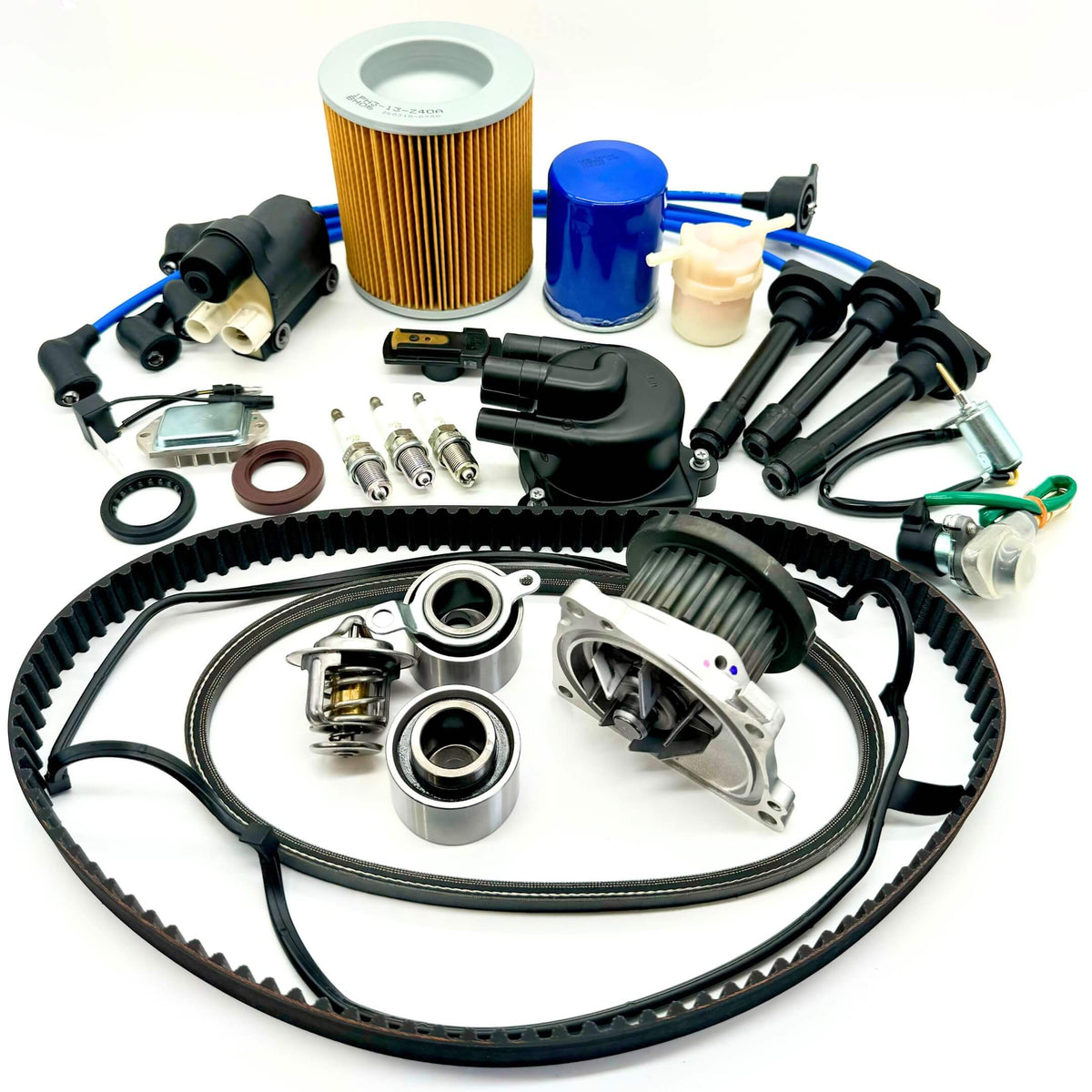 21-piece Mega Timing Belt and Tune-Up Kit for 1990-1999 Honda Acty HH3/HH4 displayed on a white background, featuring an air filter, fuel filter, oil filter, distributor cap and rotor, spark plugs with wires, ignition control module, coil sensor, ignition assembly, complete engine gasket set, and timing and alternator belts, available for order with free shipping at Oiwa Garage.