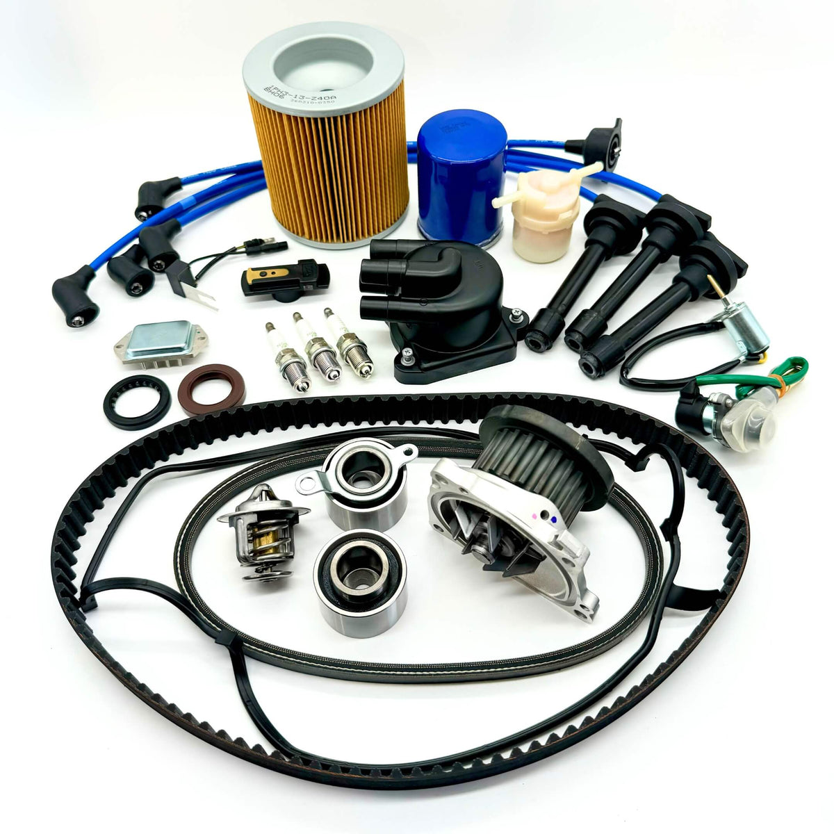 20-piece Mega Timing Belt and Tune-Up Kit for 1990-1999 Honda Acty HH3/HH4 featuring air filter, fuel filter, oil filter, distributor cap and rotor, spark plugs with wires, ignition control module, coil sensor, and complete engine gasket set with timing and alternator belts, displayed on a clean white background, available with free shipping at Oiwa Garage.